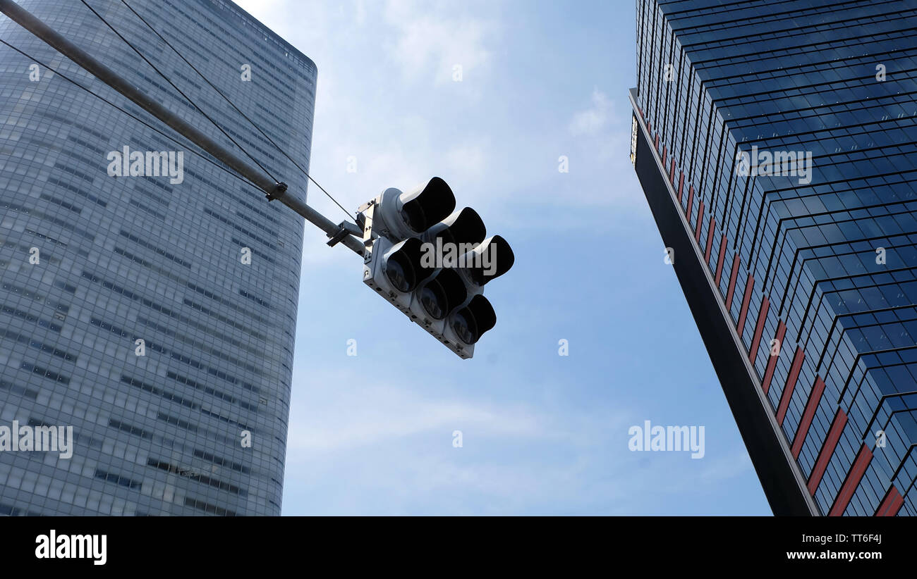 Tokyo, Japan - 13. Mai 2019: eine Ampel mit zwei Hochhäusern im Hintergrund. Blick auf ein Winkel nach oben. Stockfoto