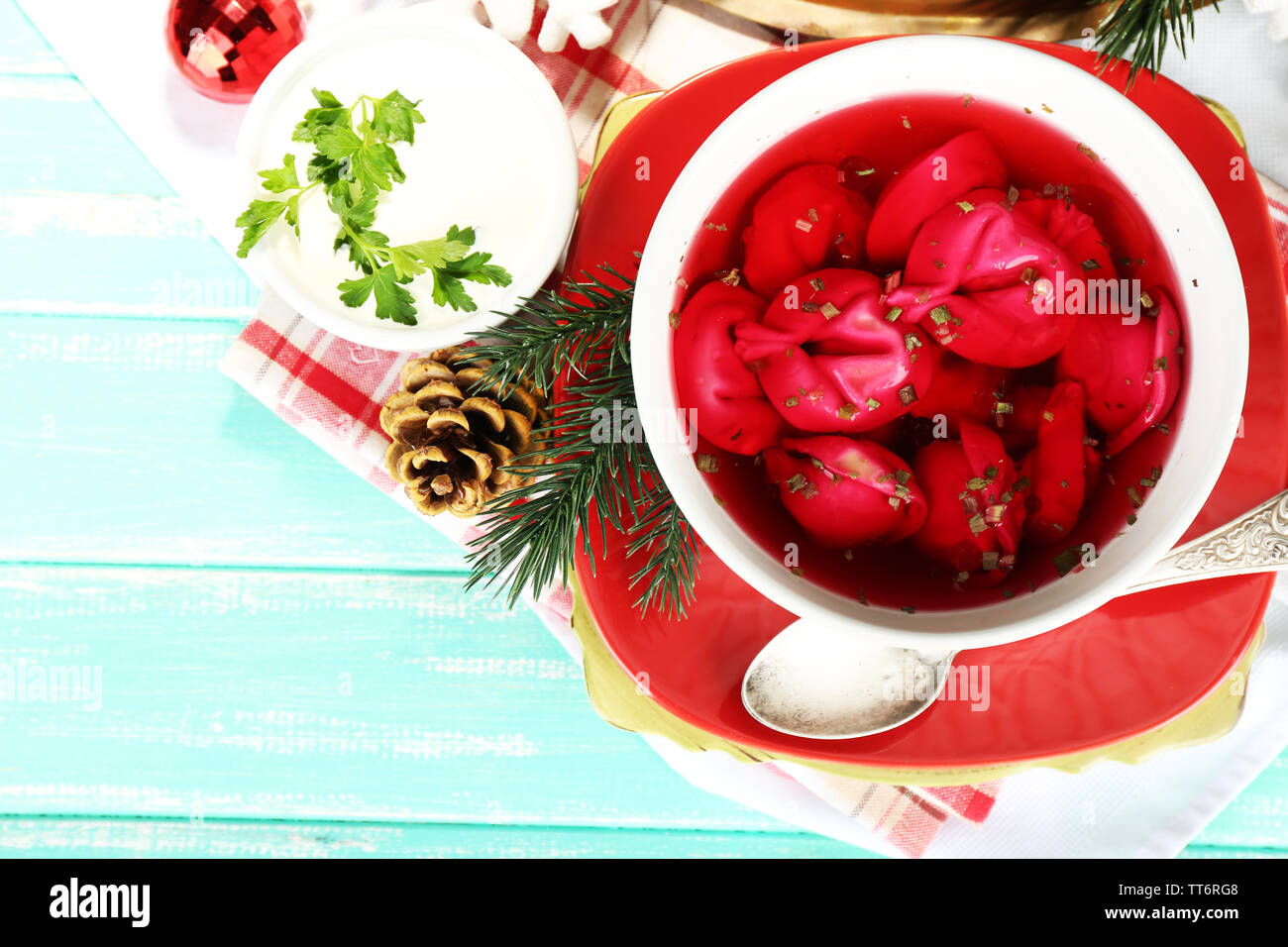 Traditionelle polnische klar rot Borschtsch mit Knödeln und Weihnachtsschmuck auf Farbe holztisch Hintergrund Stockfoto