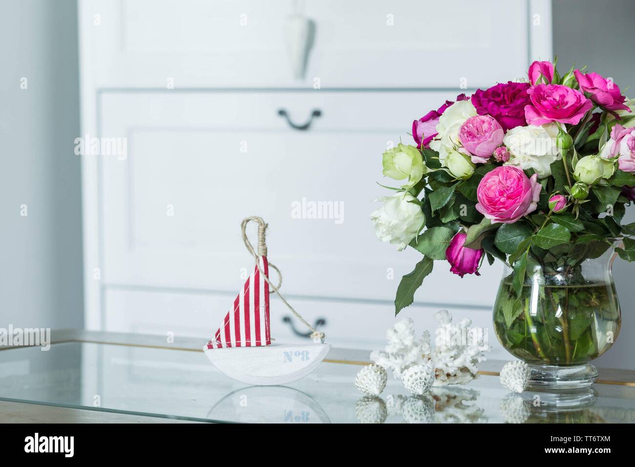 Innenbereich im Hampton Style - frische Blumen, Muscheln, Segelboot Dekorationen Stockfoto