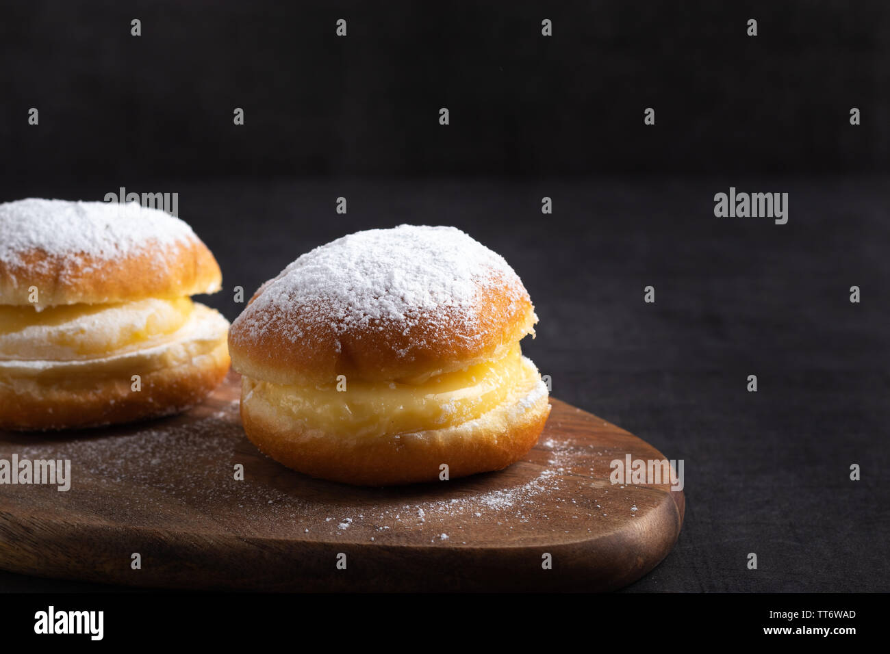 Hausgemachte Berliner Donuts auf einem Tisch in der Nähe auf einem dunklen Hintergrund Stockfoto