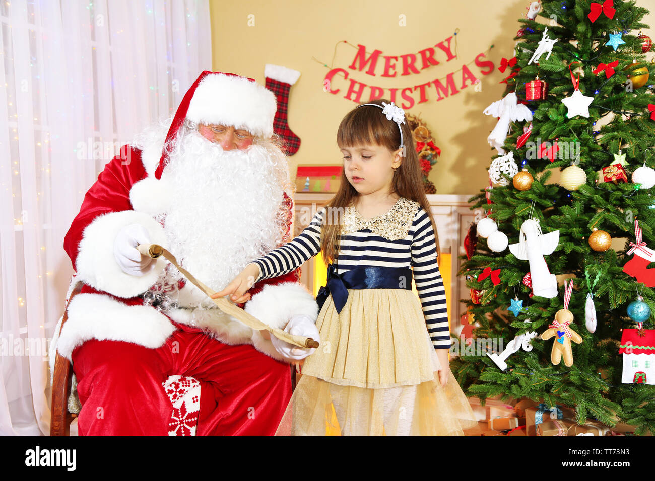 Kleine süße Mädchen geben Brief mit Wünsche an den Weihnachtsmann in der Nähe von Weihnachten zu Hause Stockfoto
