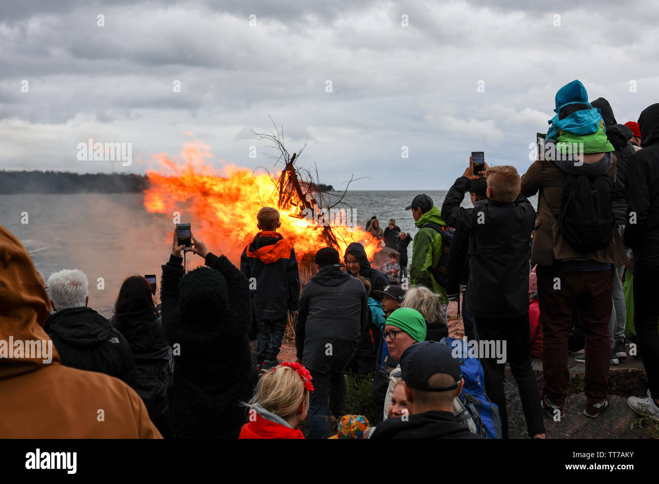 Traditionelle Hochsommer Lagerfeuer am Meer in Lauttasaari Bezirk, Helsinki Stockfoto