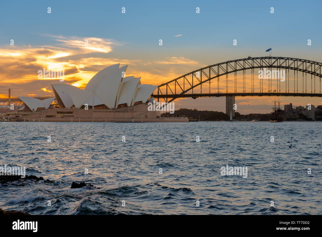 Die Sydney Harbour Bridge und Opera House - Sehenswürdigkeiten an den Ufern des Paramatta River bei Sonnenuntergang Stockfoto
