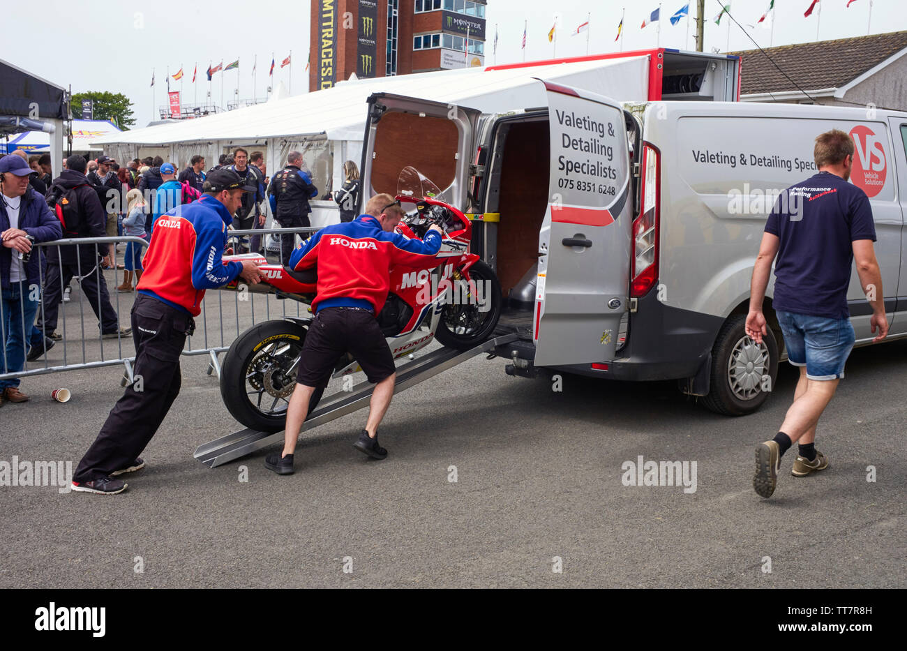 Die Mitglieder des Honda Team laden ein Fahrrad in die Rückseite eines Van nach der Senior TT Rennen im Jahr 2019 Stockfoto