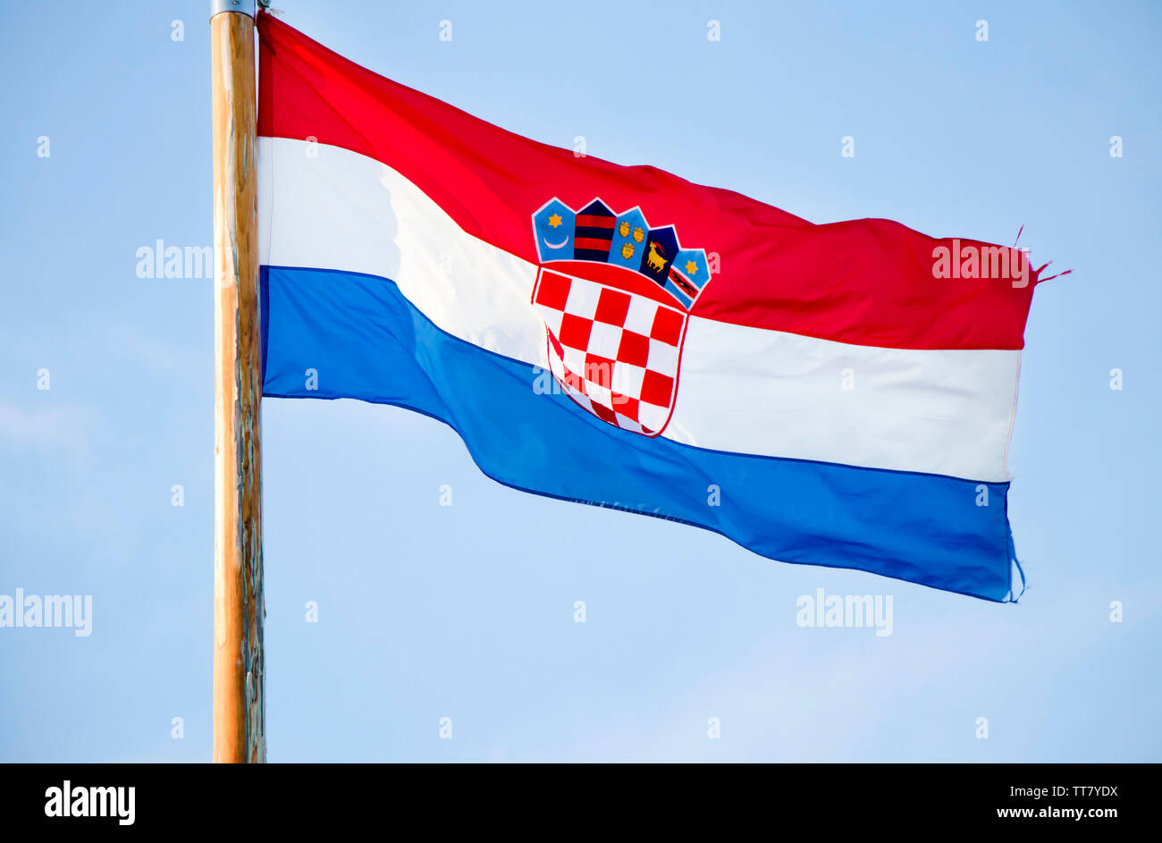 Kroatische Nationalflagge flattern auf hölzerne Stange gegen den blauen Himmel Stockfoto