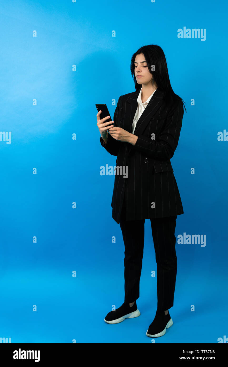 Gerne erfolgreiche Frau Blick auf Smartphones. Happy bussiness Frau. Vertikale Foto. mittellange Aufnahme Stockfoto