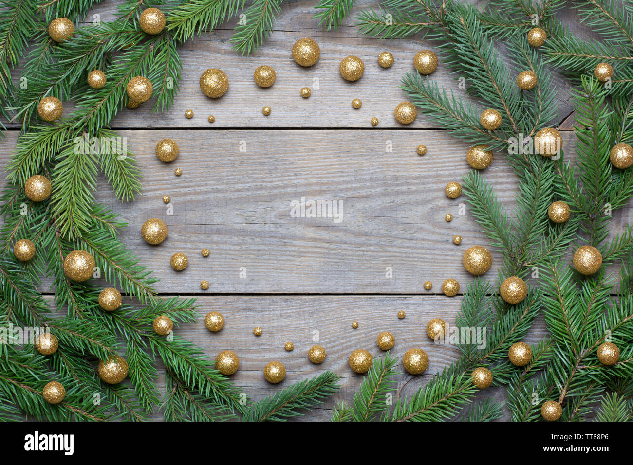 Weihnachtskarte mit Tannenbaum, Zweige und Brocade Kügelchen in einem Kreis auf Holz- Hintergrund angeordnet - text Raum Stockfoto