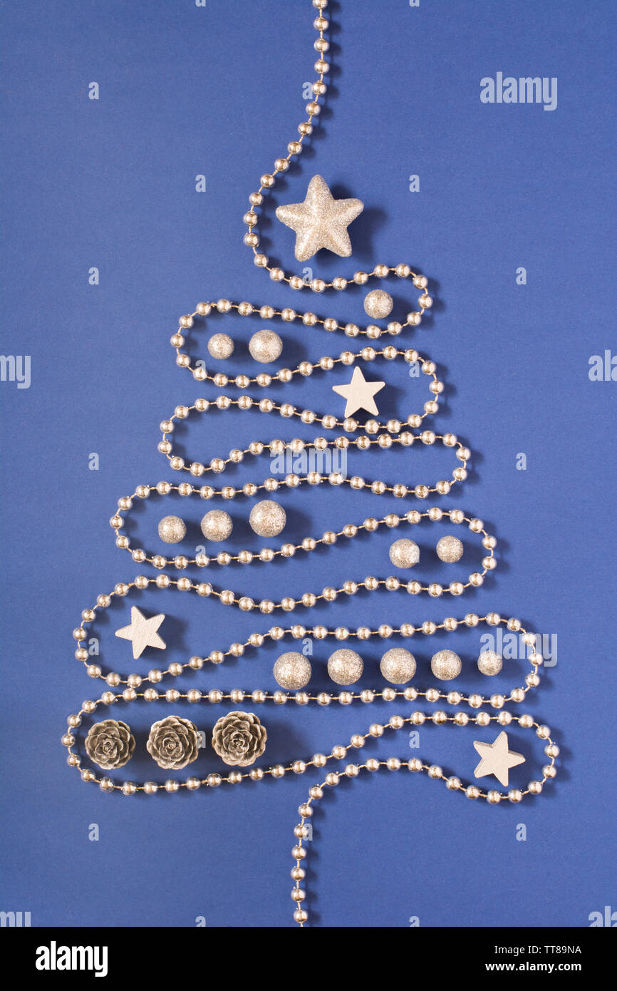 Weihnachtsbaum Konzept mit silbernen Perlen Kette, Silber Sterne, Kegel und  Globuli auf dunkelblauem Hintergrund Stockfotografie - Alamy