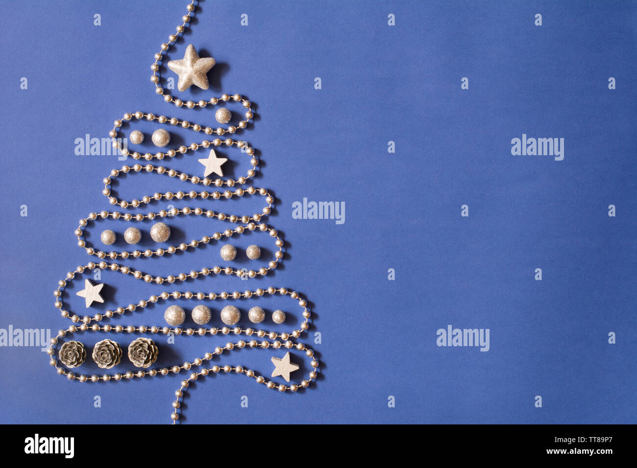 Weihnachtsbaum Konzept mit silbernen Perlen Kette, Silber Sterne, Kegel und Globuli auf dunkelblauem Hintergrund, tiefe Schatten-text-Raum Stockfoto