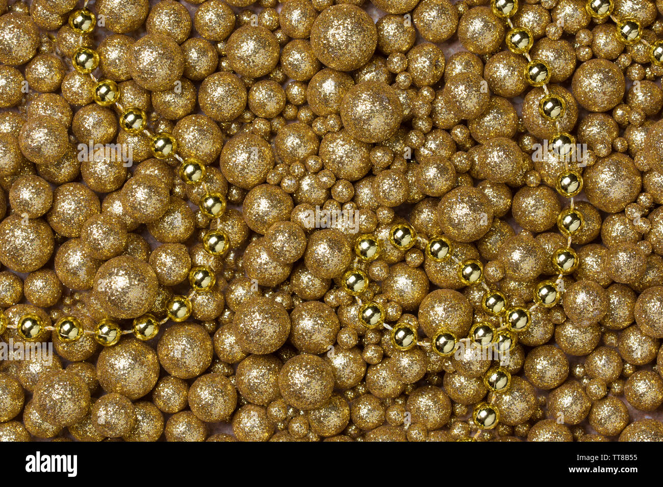 Weihnachten Hintergrund mit großen und kleinen goldenen glitter Kugeln und goldenen Perlen Kette Stockfoto