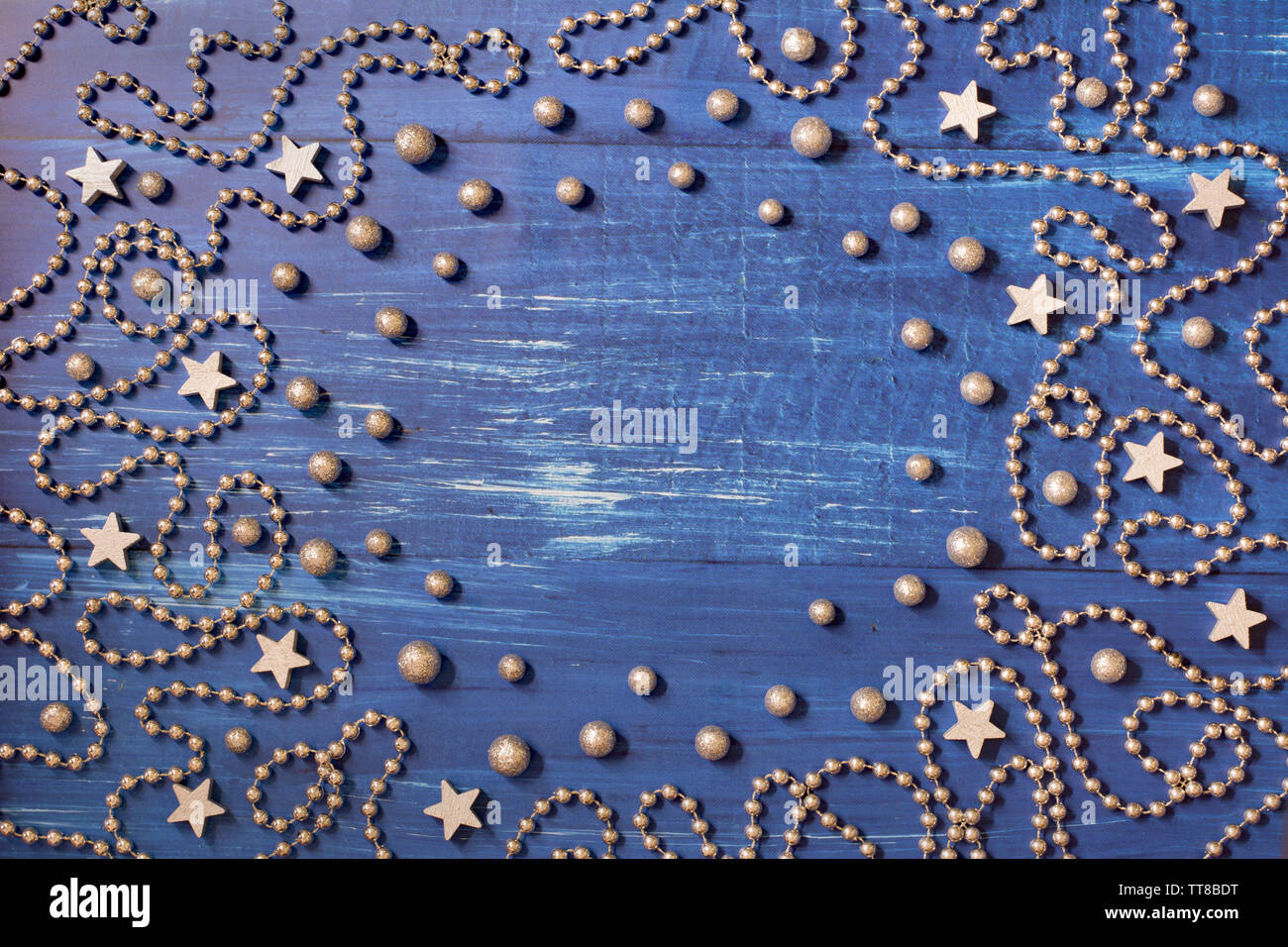 Weihnachtsdekoration mit silbernen Perlen Kette und Sterne auf dunkelblauem Hintergrund Holz - Platz für Text in der Mitte Stockfoto