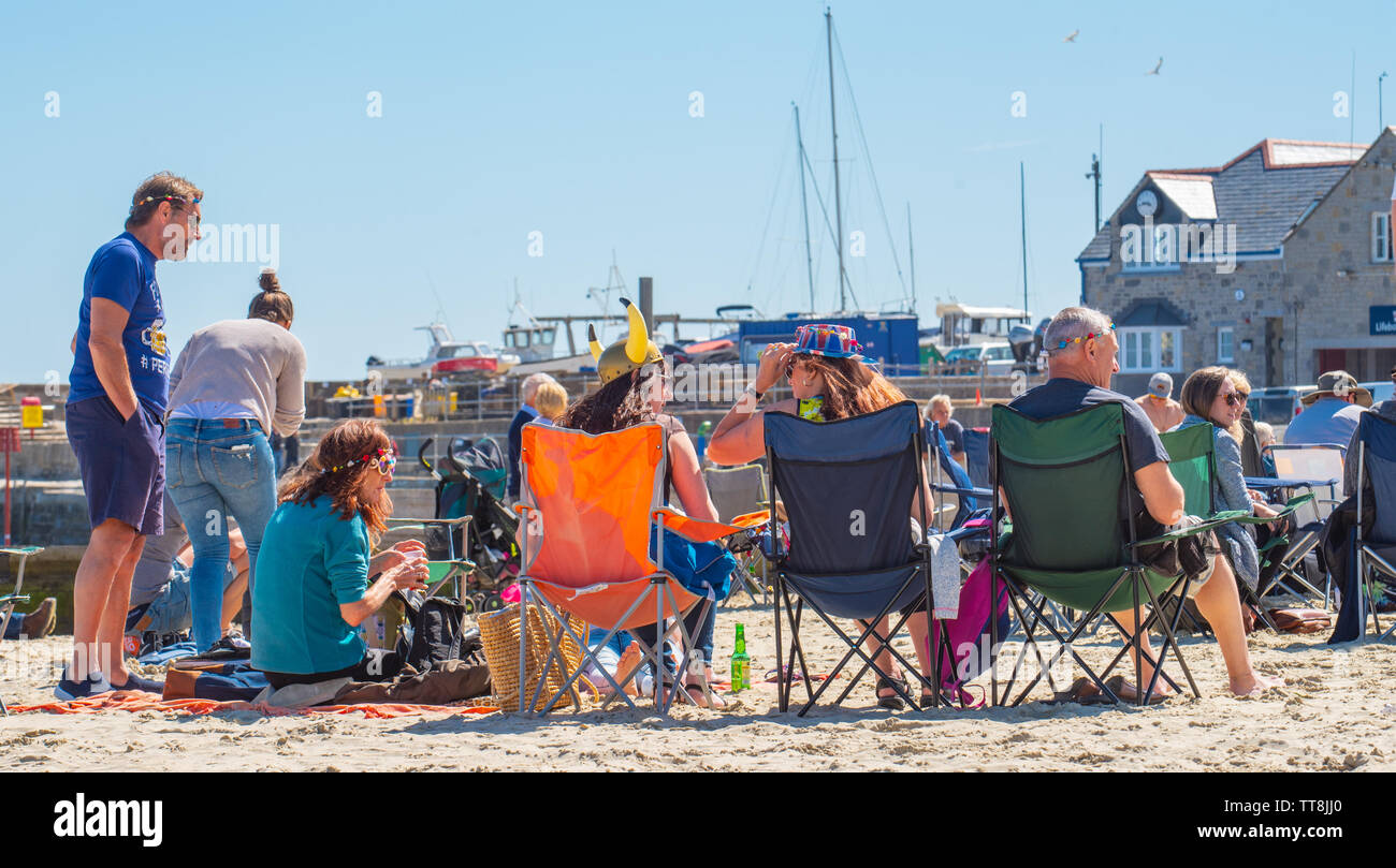 Lyme Regis, Dorset, Großbritannien. 15 Juni, 2019. UK Wetter: Massen von Musiker und Besucher strömen zum Strand genießen Sie einen Nachmittag mit Musik als die jährliche Gitarren am Strand Veranstaltung erhält unterwegs am Strand in Lyme Regis an einem herrlichen Nachmittag im warmen Sonnenschein und strahlend blauen Himmel. Die Masse ist der Star der Show als Gitarristen aller Altersgruppen und Fähigkeiten zusammen am Strand versammeln sich als "größten der britischen Band' durchführen. Die Menschen genießen die entspannte Atmosphäre des Festivals, bevor Sie in diesem Jahr gewählten Song "am Strand" durchführen. Credit: Celia McMahon/Alamy leben Nachrichten Stockfoto