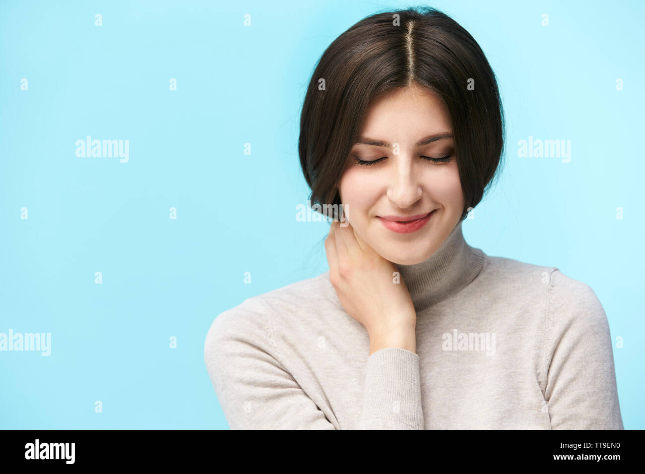 Porträt einer schönen jungen kaukasischen Frau, glücklich und lächelnd die Augen geschlossen, auf blauem Hintergrund isoliert Stockfoto