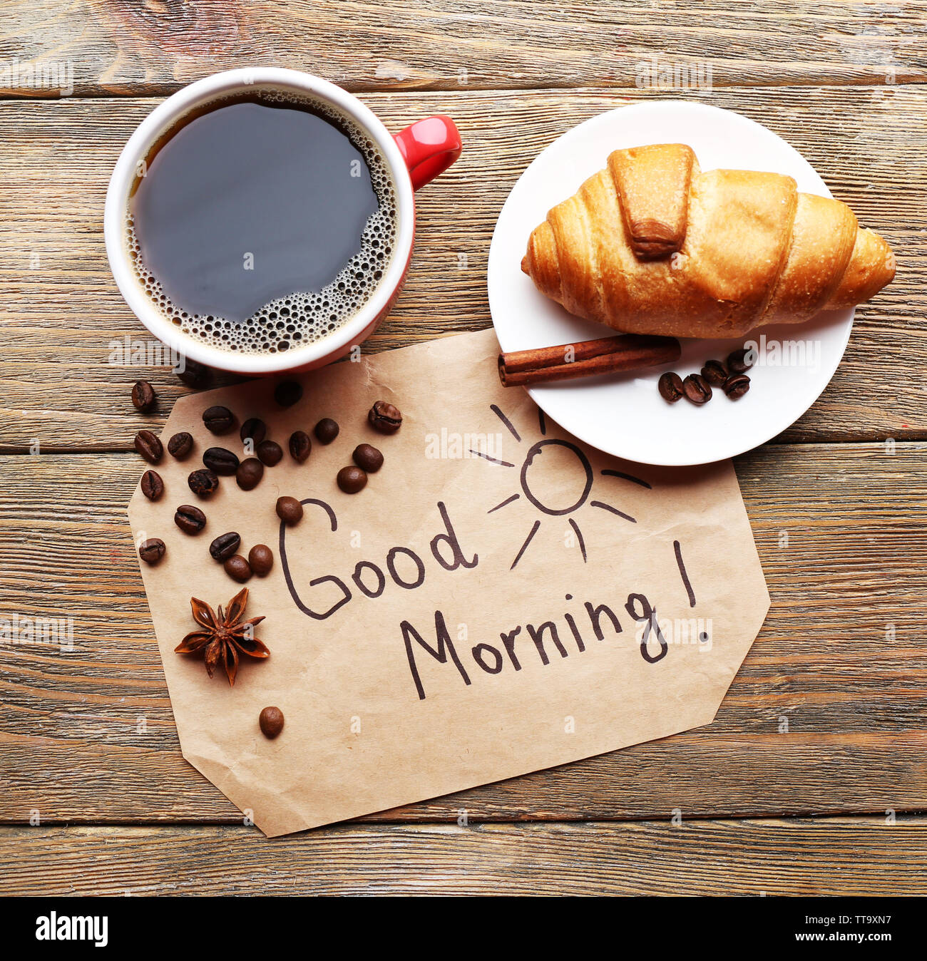 Tasse Kaffee mit frischen Croissants und Guten Morgen Massage auf Holztisch, Ansicht von oben Stockfoto