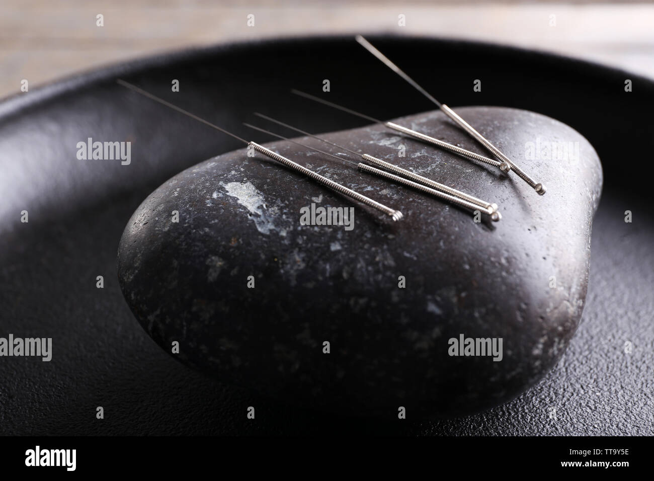 Akupunktur Nadeln mit einem Stein auf Fach, Nahaufnahme Stockfoto