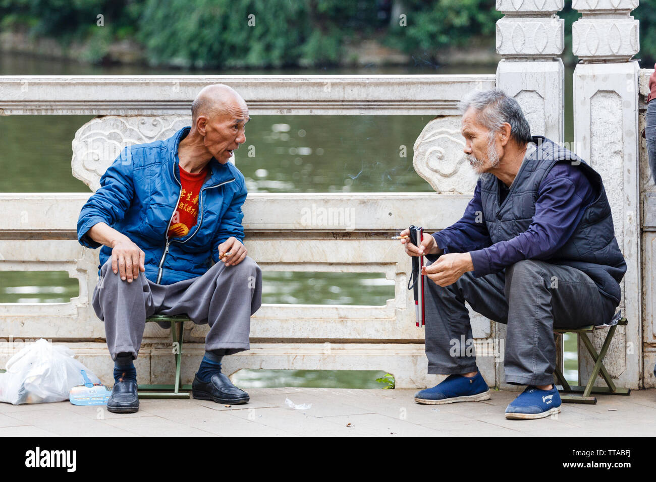 Porträt von zwei Ältesten in einem Park in Kunming City chatten Stockfoto