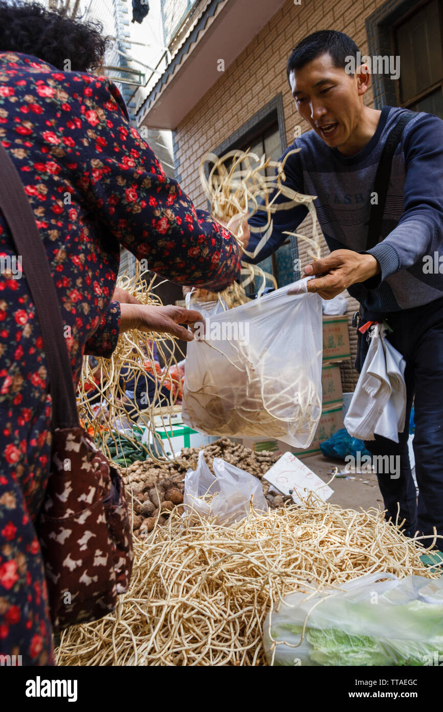 14.02.2018, Kunming, China Anbieter verkauft genießbare Wurzeln an den lokalen Markt Stockfoto