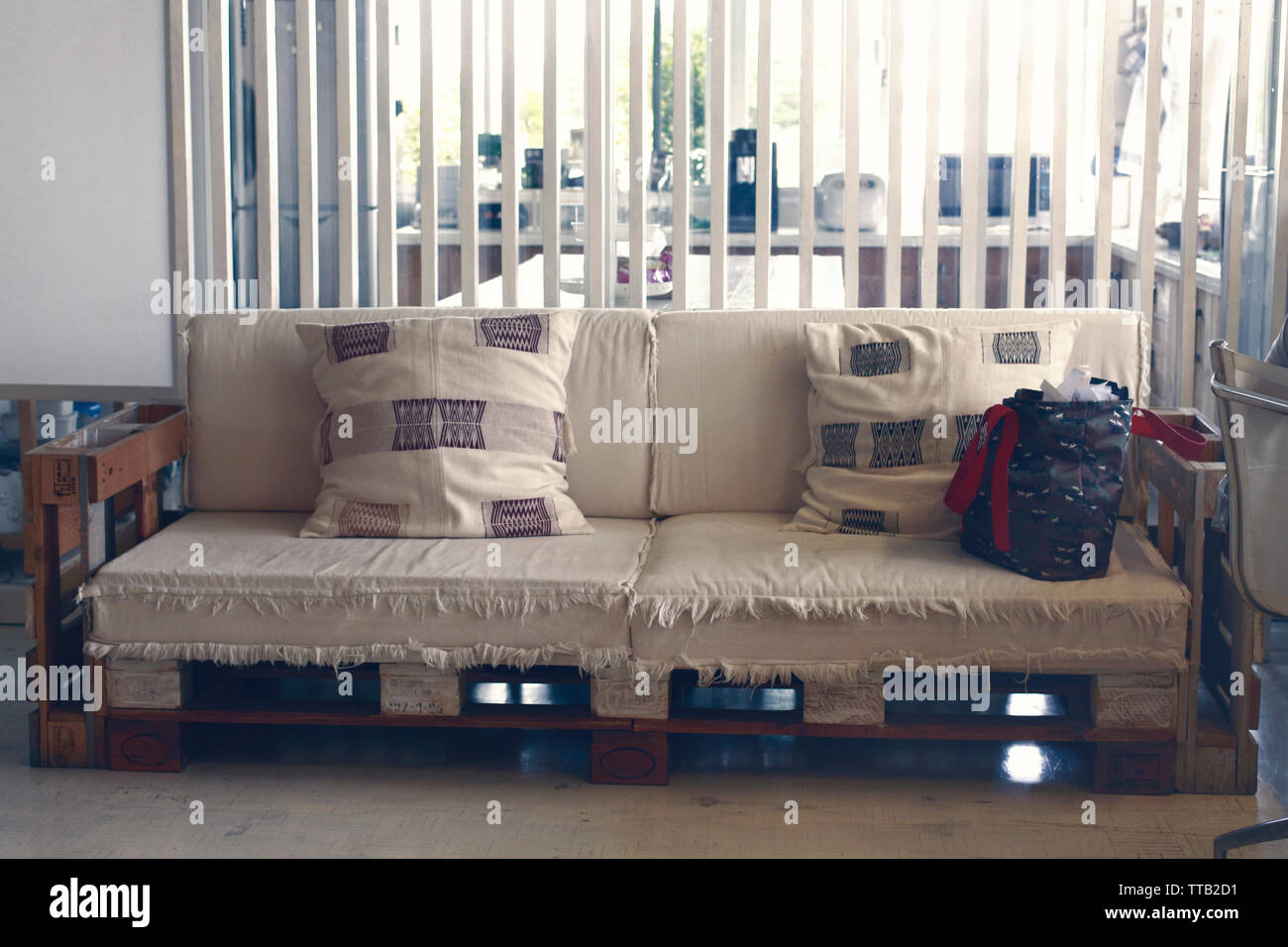 Eine Kreativität Sofa aus Holzpaletten und Alten aus weißem Stoff Stockfoto