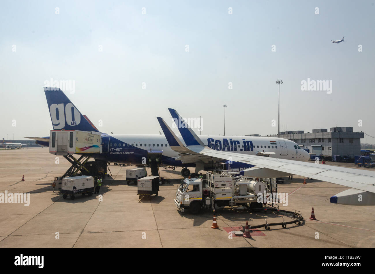 Das Bodenpersonal in Woking an einem Airbus A320 GoAir Flug wie von der parallelen geparkt IndiGo Airlines Flug zum Internationalen Flughafen Indira Gandhi gesehen, Delhi Stockfoto