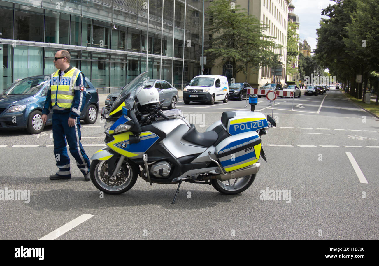 Hannover, Juni 8., 2019: Polizisten mit Warnweste und Sonnenbrille steht  neben seiner Polizei Motorrad mit seinem Helm aus Stockfotografie - Alamy