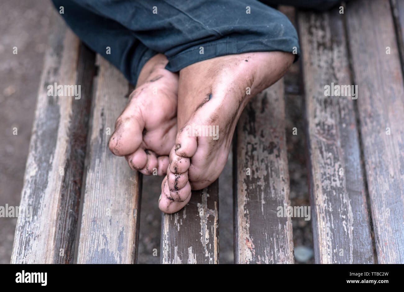 Obdachloser auf der Werkbank, Nahaufnahme schmutzige Beine der Bettler Stockfoto