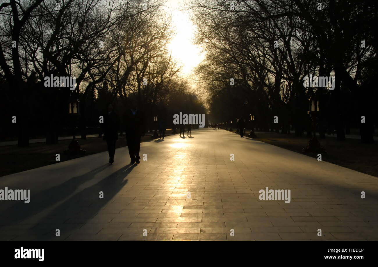 Wandern auf dem Gelände der Himmelstempel (tiantan) in Peking, China, mit Sonne, Bäume und lange Schatten. Tian Tan, Tempel des Himmels, Park, Pfad Stockfoto