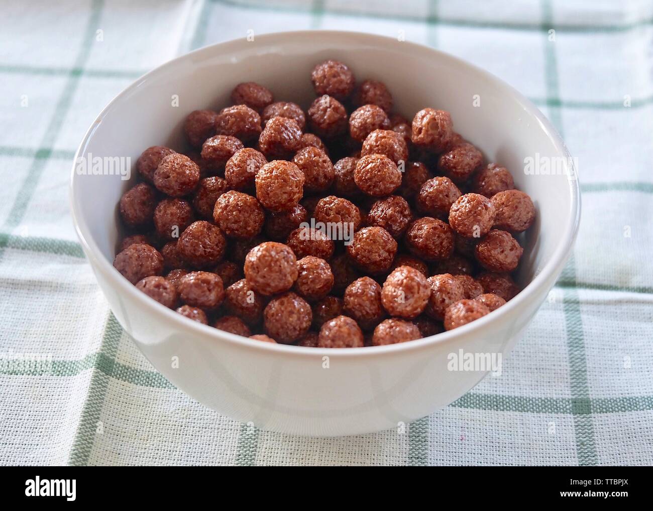 Schokolade Cornflakes in eine Schüssel, ein Frühstück Müsli durch Schiebeschalter Flocken von Getreide oder Mais hergestellt werden Stockfotografie