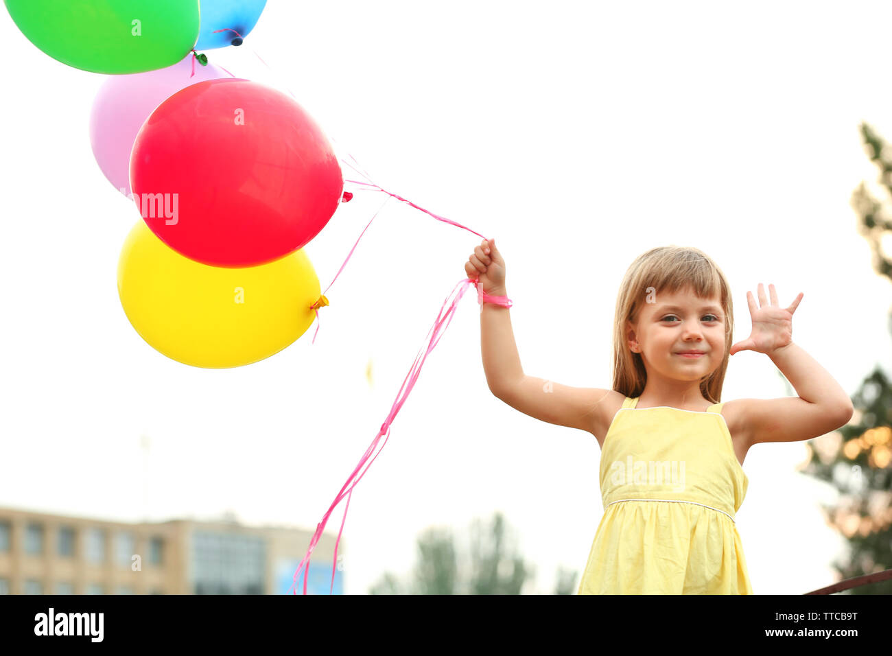 Kleines Mädchen mit Ballons außerhalb Stockfoto