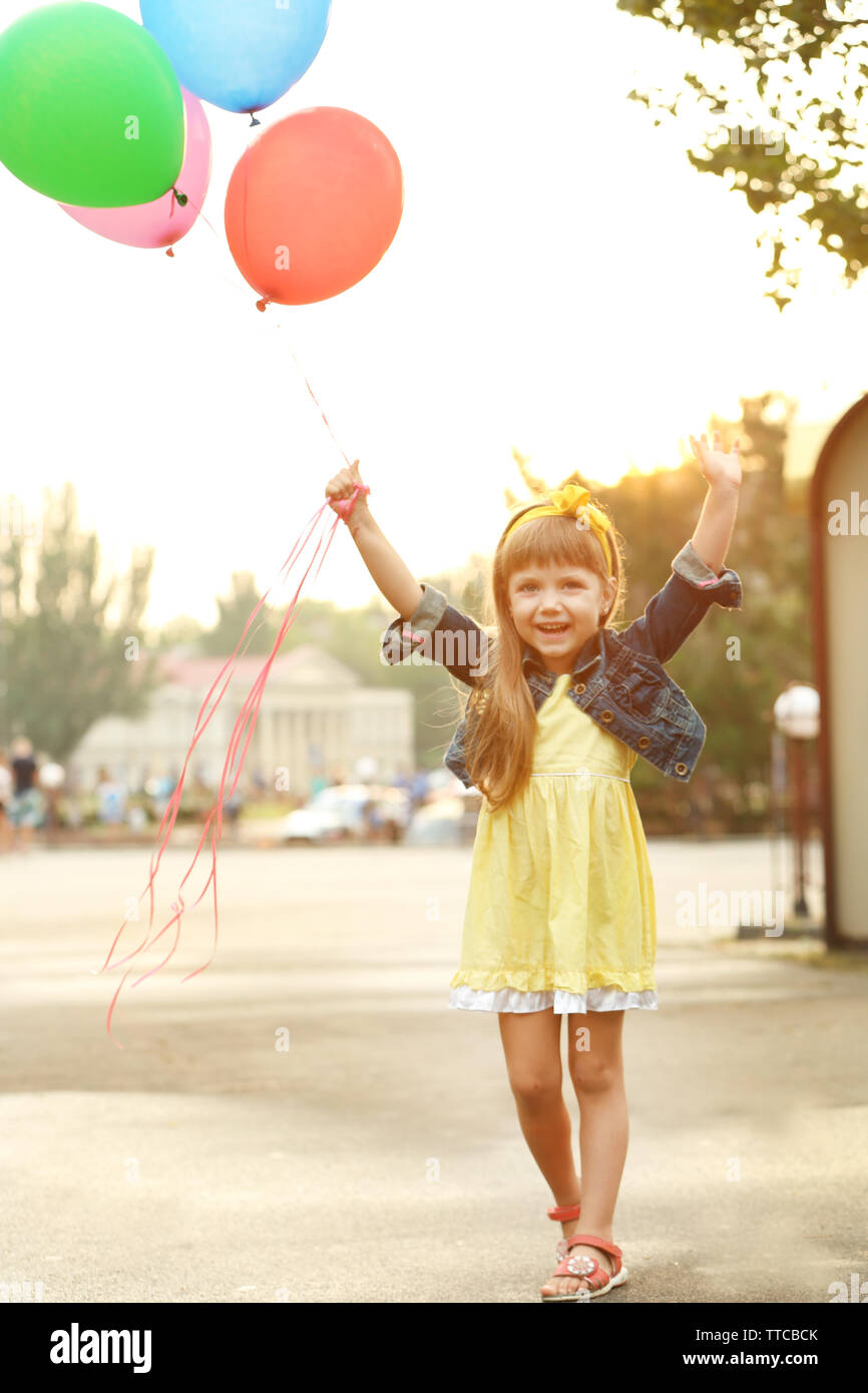 Kleines Mädchen mit Ballons außerhalb Stockfoto
