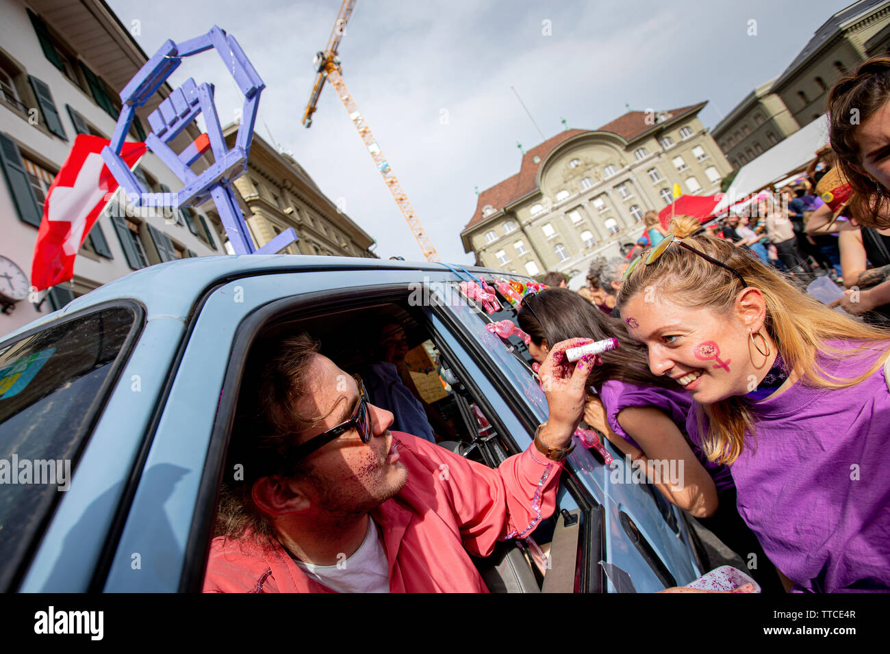 Jonas in der Glitterflitzerin Bus gilt lila Glitzer auf dem Gesicht von Livia Rothenlfuh aus Bern. Der Frauenstreik - Frauen Streik - brachte den Rekordzahlen von Frauen auf den Straßen in alle großen Städte der Schweiz. In der Hauptstadt Bern, mehr als 40.000 marschierten in der ganzen Stadt für die Gleichstellung zu kämpfen. Stockfoto