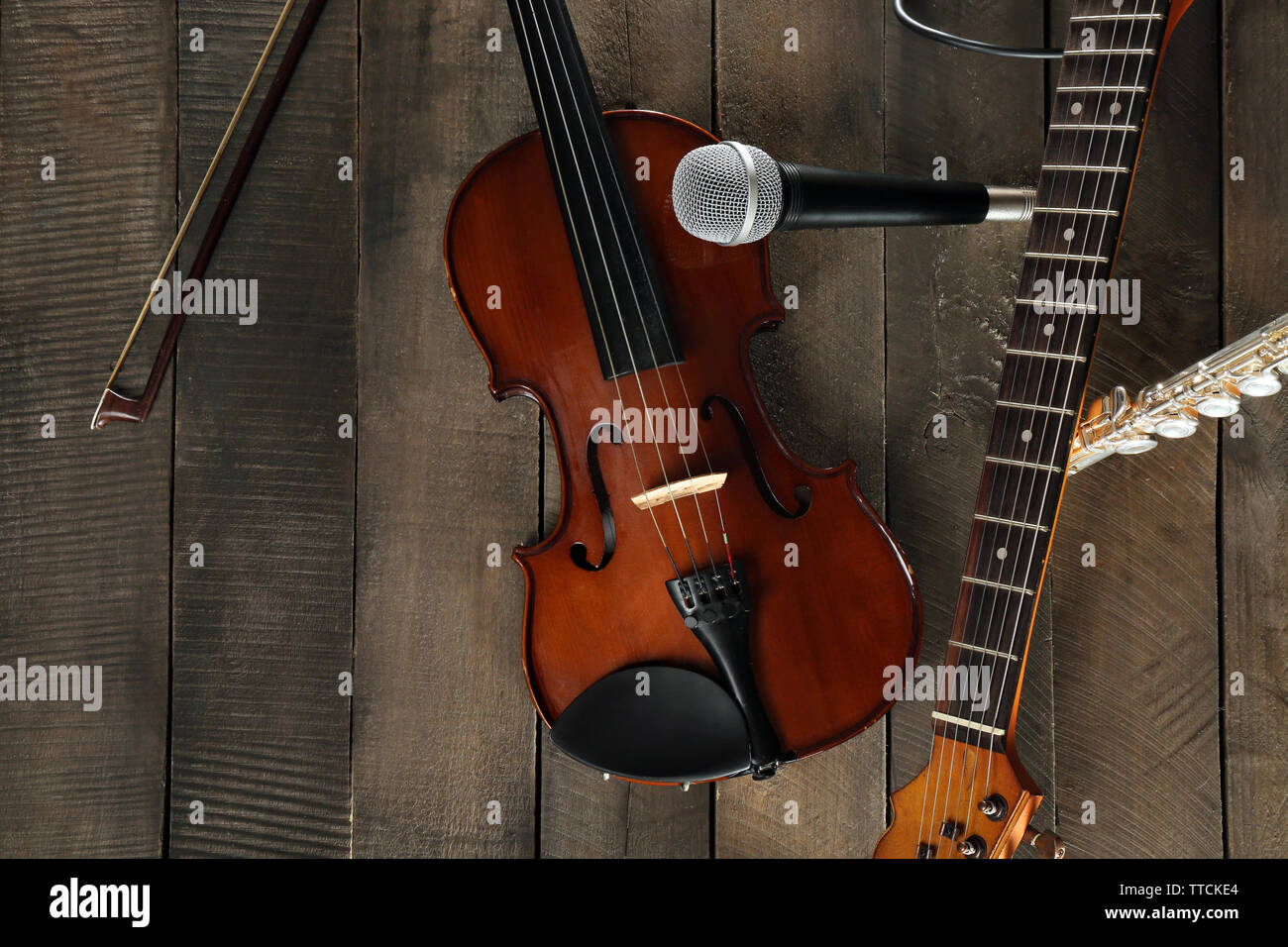 E-Gitarre, Geige, Flöte und Mikrofon auf Holz- Hintergrund Stockfotografie  - Alamy