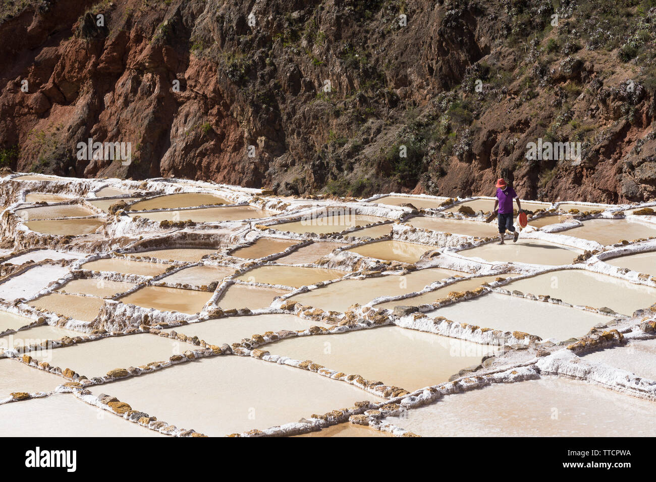Ein Mann zu Fuß entlang der Salinen an Salineras de Maras, Peru. Stockfoto