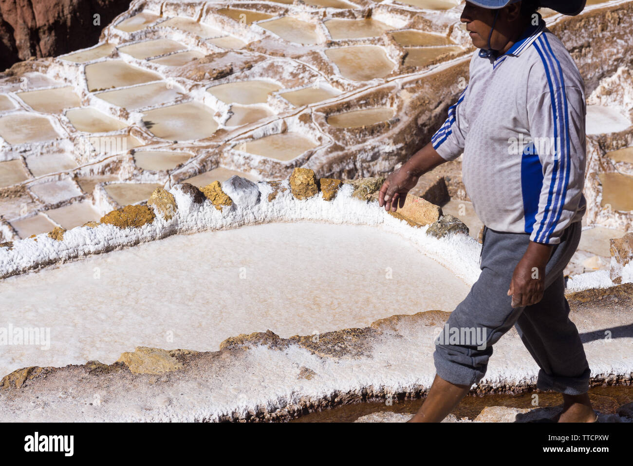 Ein Mann zu Fuß entlang der Salinen an Salineras de Maras, Peru. Stockfoto