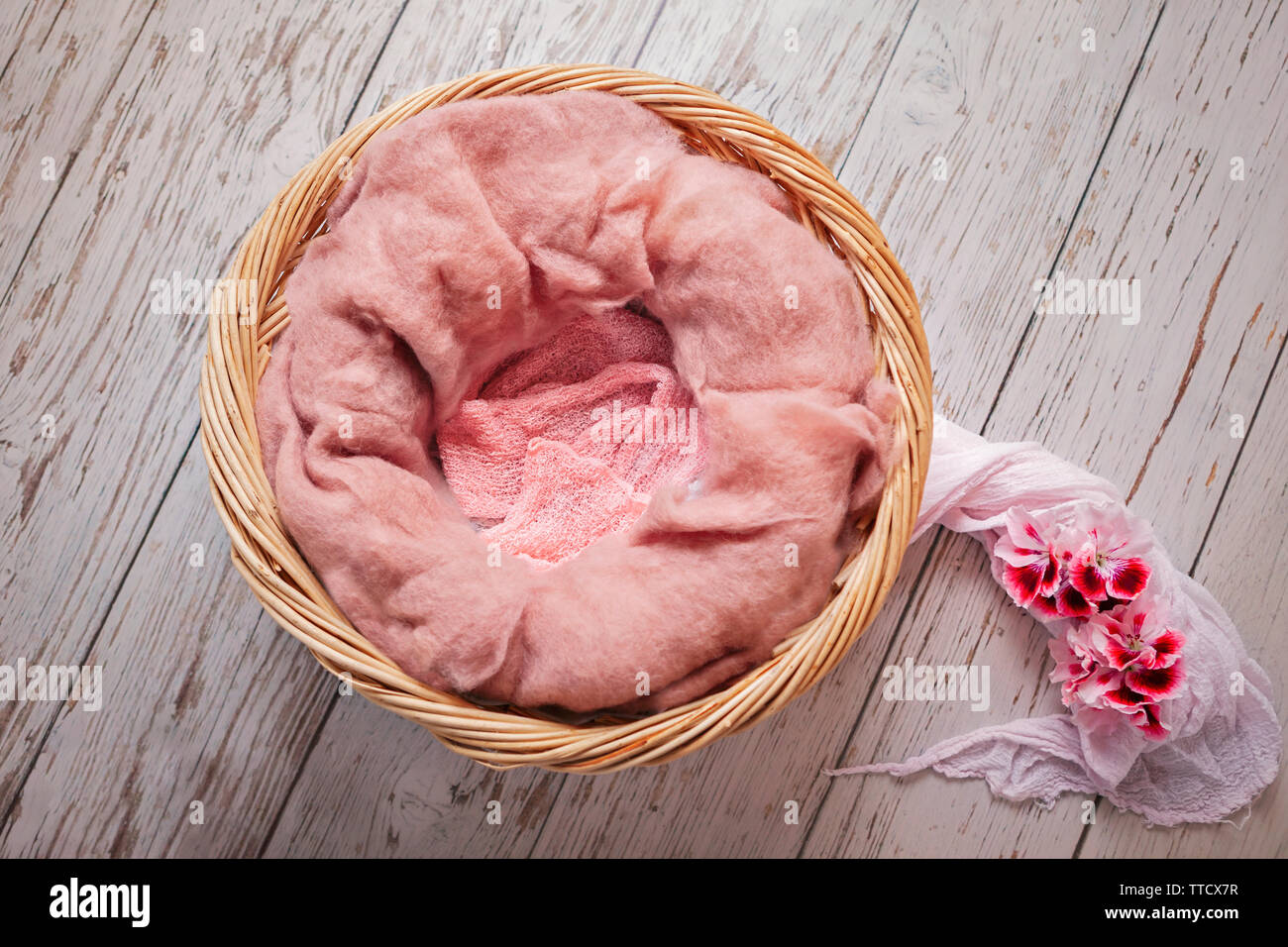 Digitale Hintergrund ... neugeborenen Korb mit rosa Flauschige wolle und rosa Blüten Stockfoto