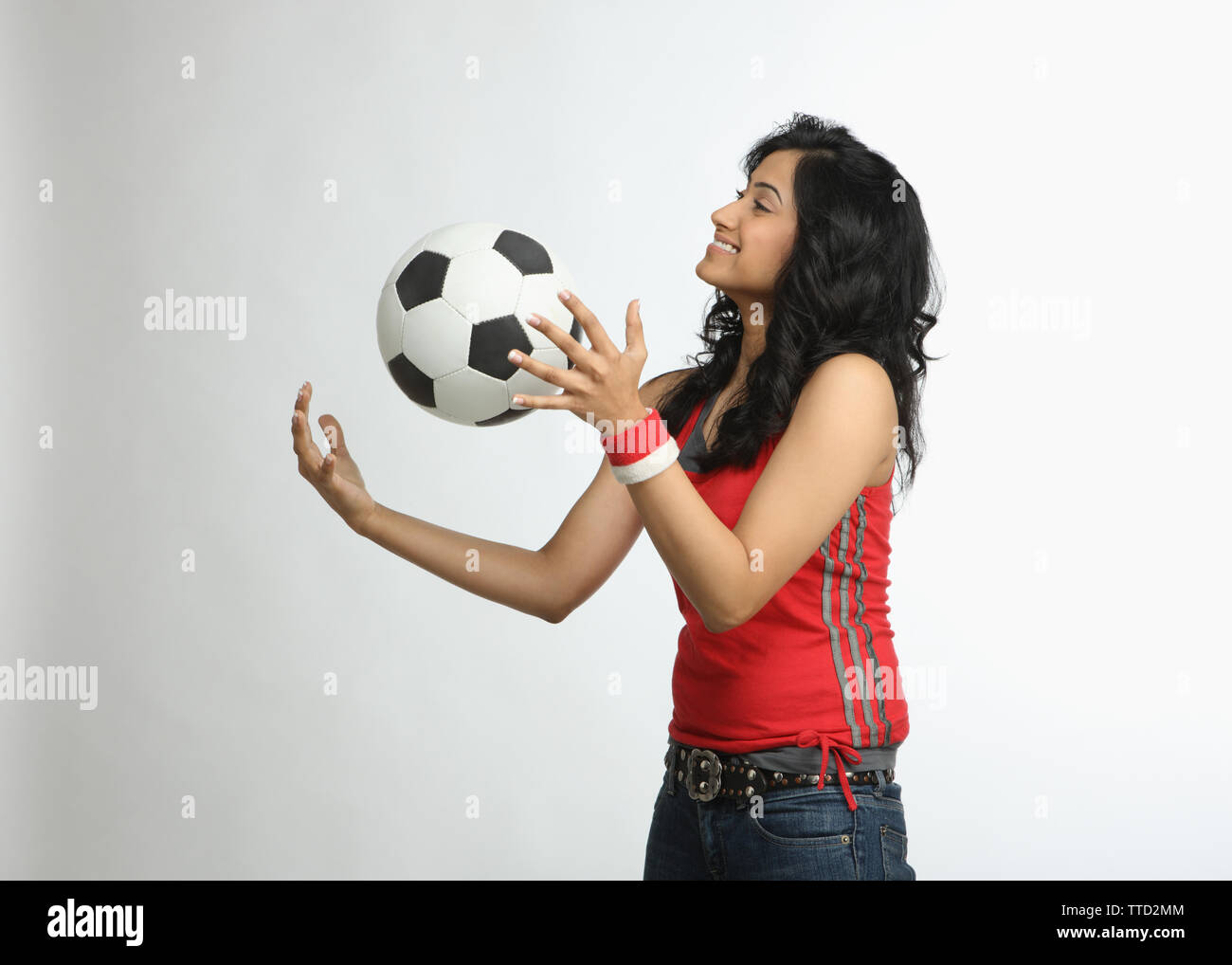 Frau mit einem Fußball zu spielen und Lächeln Stockfoto