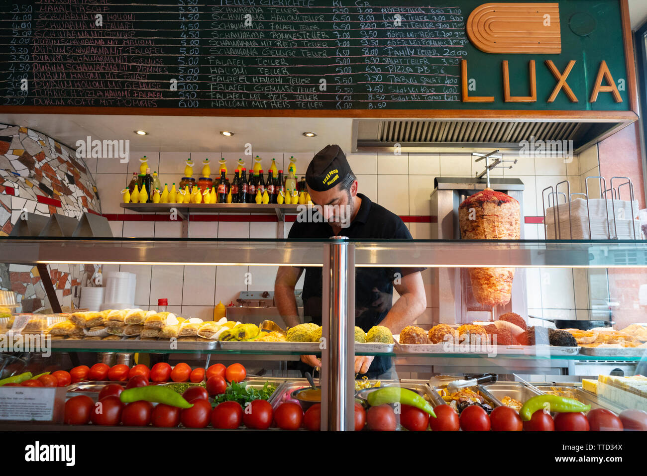 Mann Vorbereitung Schwarma Sandwich an Luxa Restaurant in Mitte, Berlin, Deutschland Stockfoto