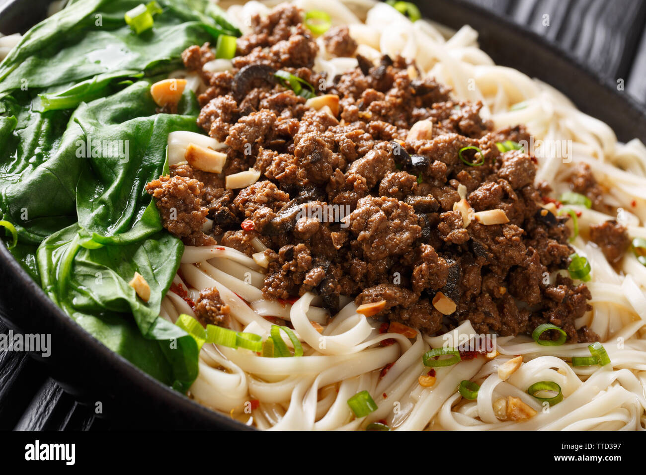 Dandan Nudeln oder dandanmianwith Hackfleisch ist Gericht aus chinesischen Sichuan Küche closeup in einem Teller auf dem Tisch. Horizontale Stockfoto
