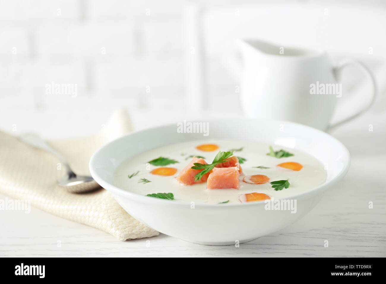 Leckere Cremesuppe mit Lachs und Karotten in weiße Schüssel Stockfoto