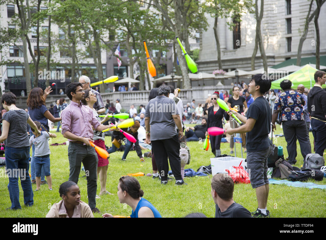 Touristen und Neue gleichermaßen Yorkers auf dem Gras am Bryant Park hinter der New York Public Library an der 42. Straße, zwischen der 5. und 6. Veranstaltungsorte in Th entspannen Stockfoto