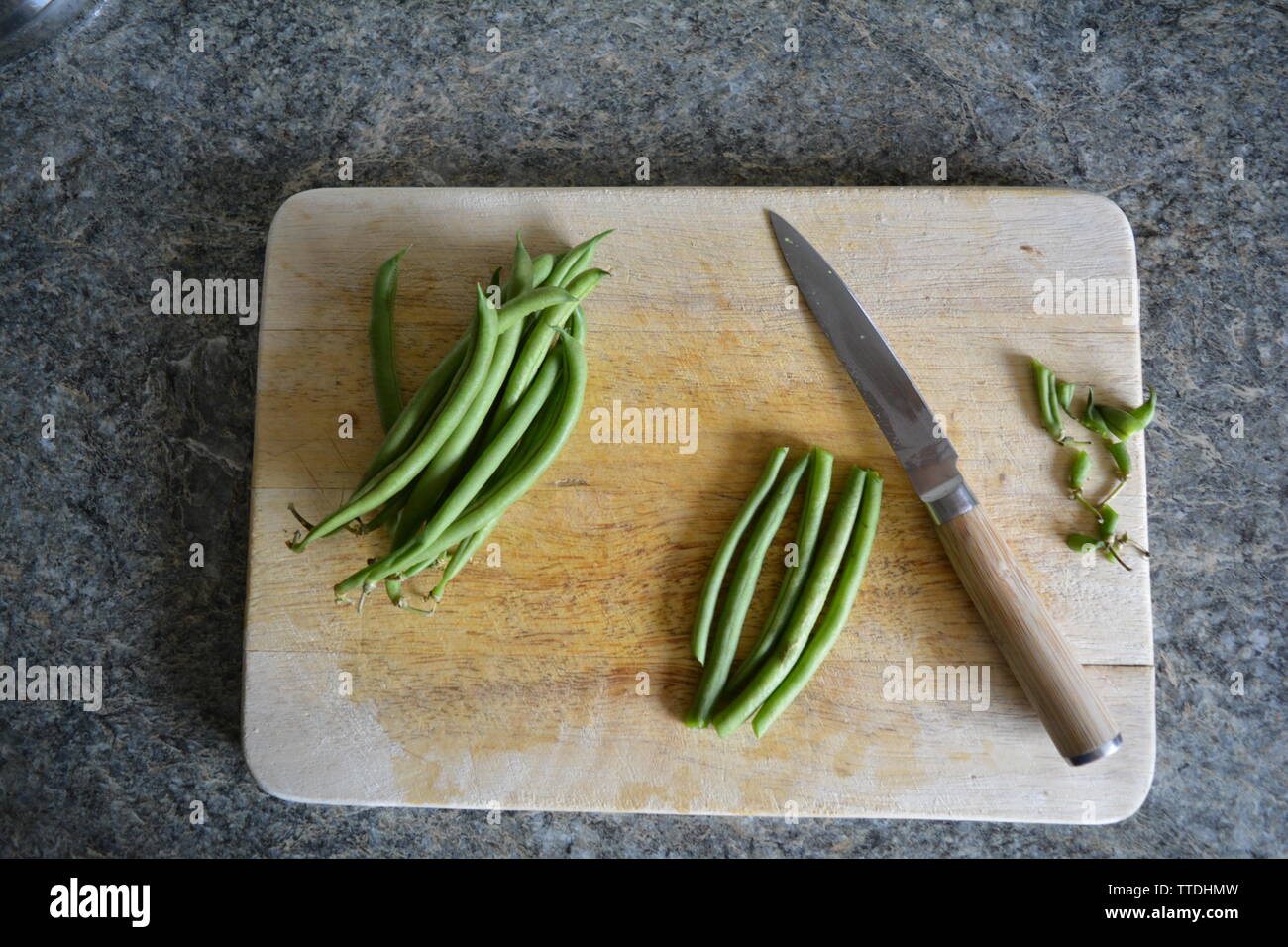 Authentische Speisen prep veg wird auf einer hölzernen Schneidebrett in einem englischen Küche, Tageslicht, Bohnen, Karotten, oder Pilz schneiden. Stockfoto