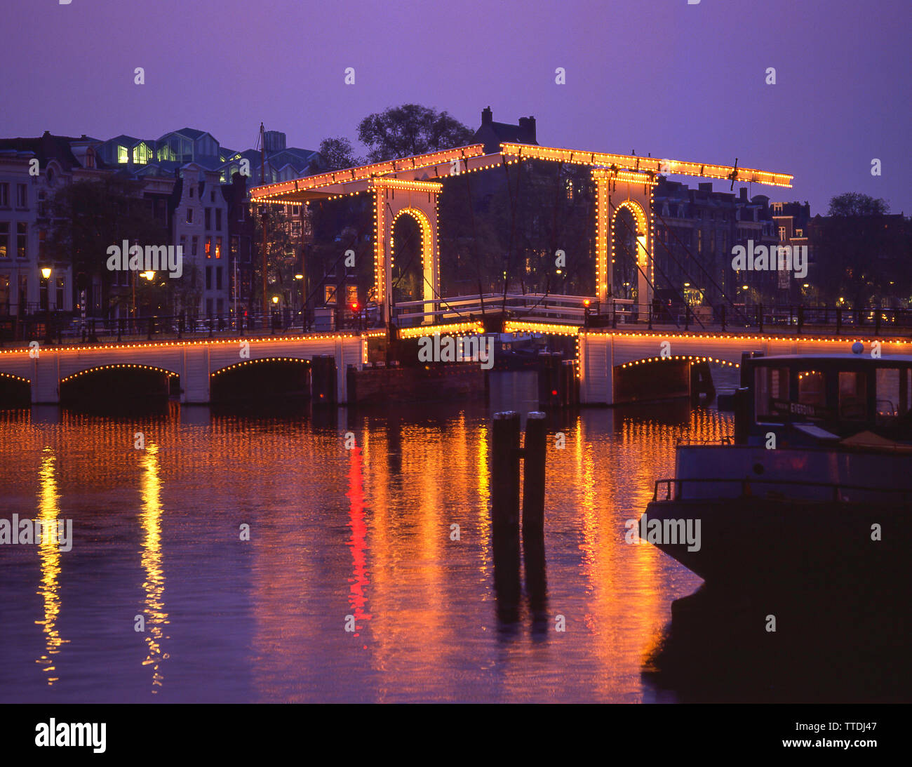 Die Magere Brug (Skinny Bridge) in der Dämmerung und den Fluss Amstel, Amsterdam, Noord-Holland, Königreich der Niederlande Stockfoto