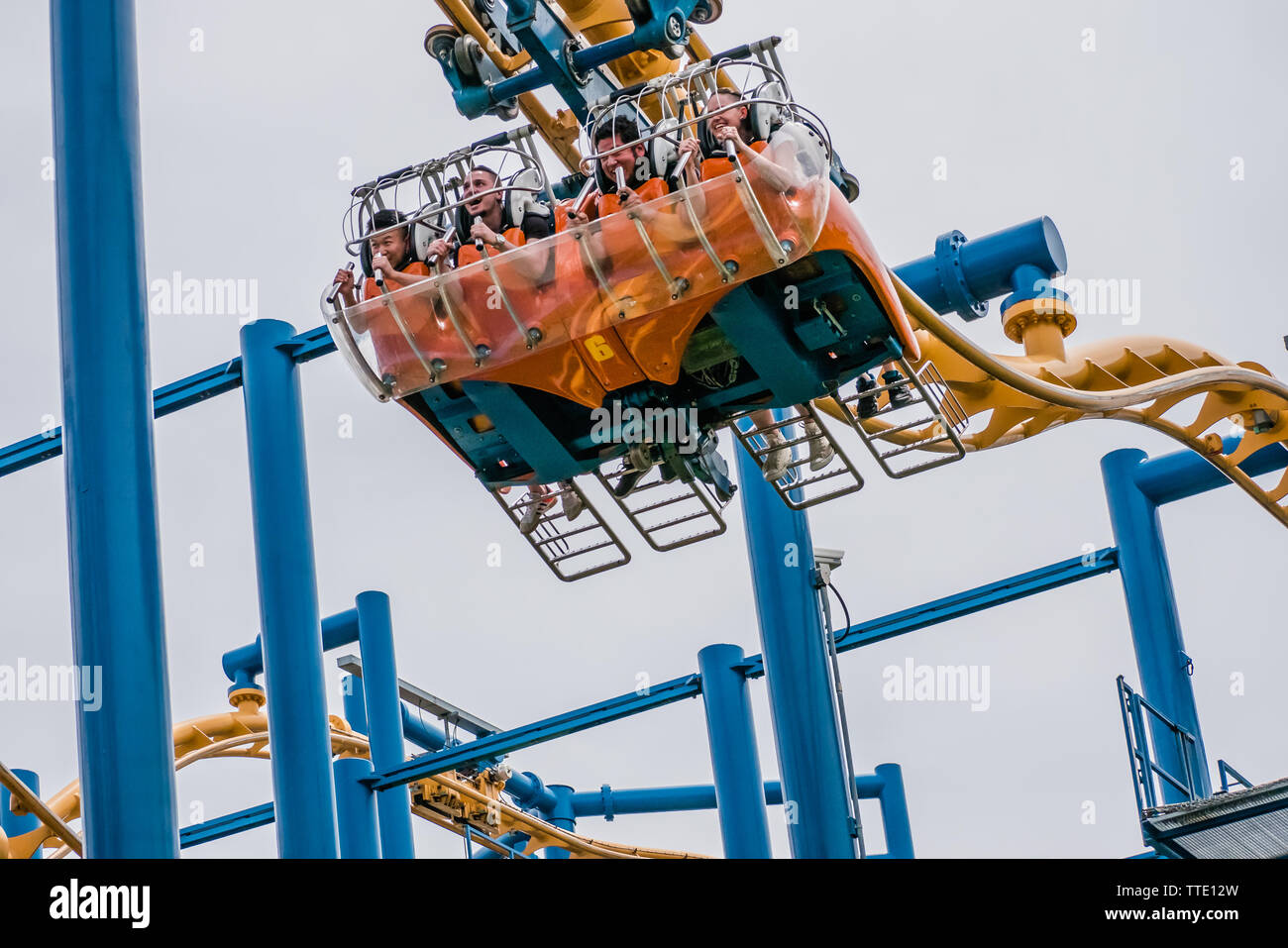 Menschen lyding nach unten anstatt nach Sitzen auf der Flying Coaster ride Time Wrap Stockfoto