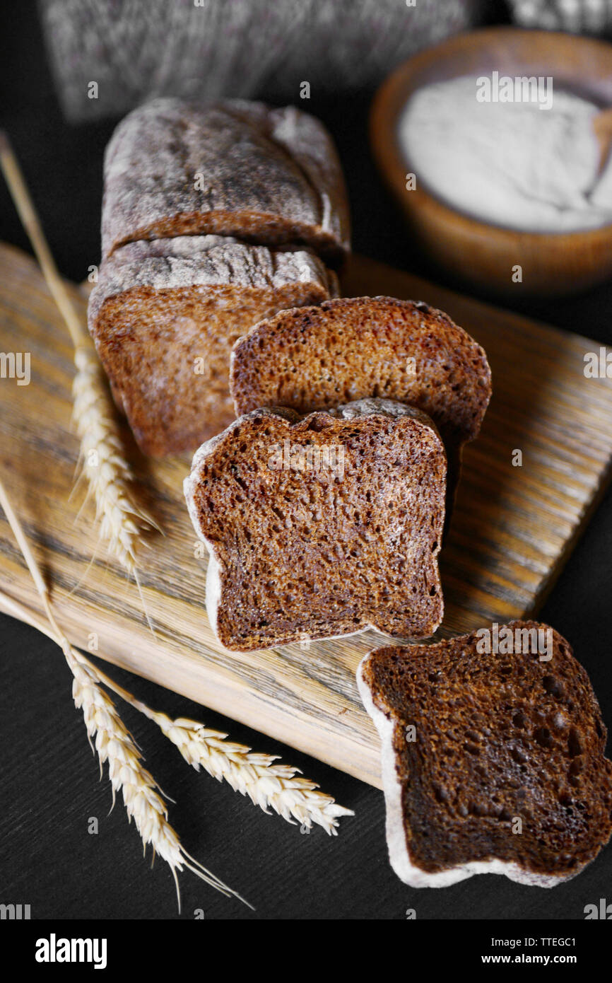 Geschnittenes Brot mit Ohren auf Schneidebrett closeup Stockfoto
