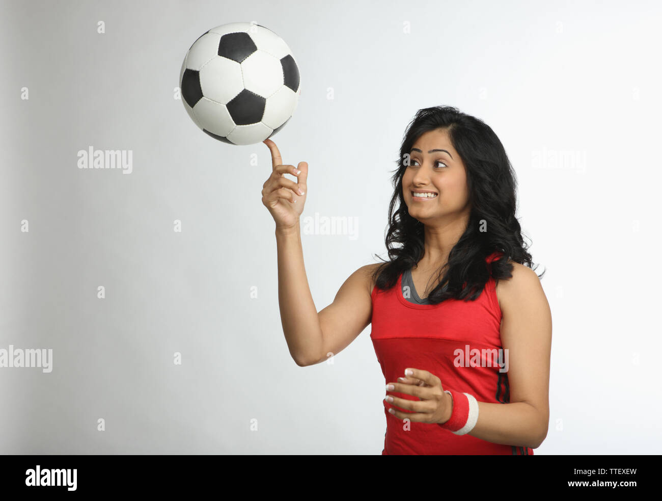 Indische Frau einen Fußball auf dem Finger balancieren Stockfoto