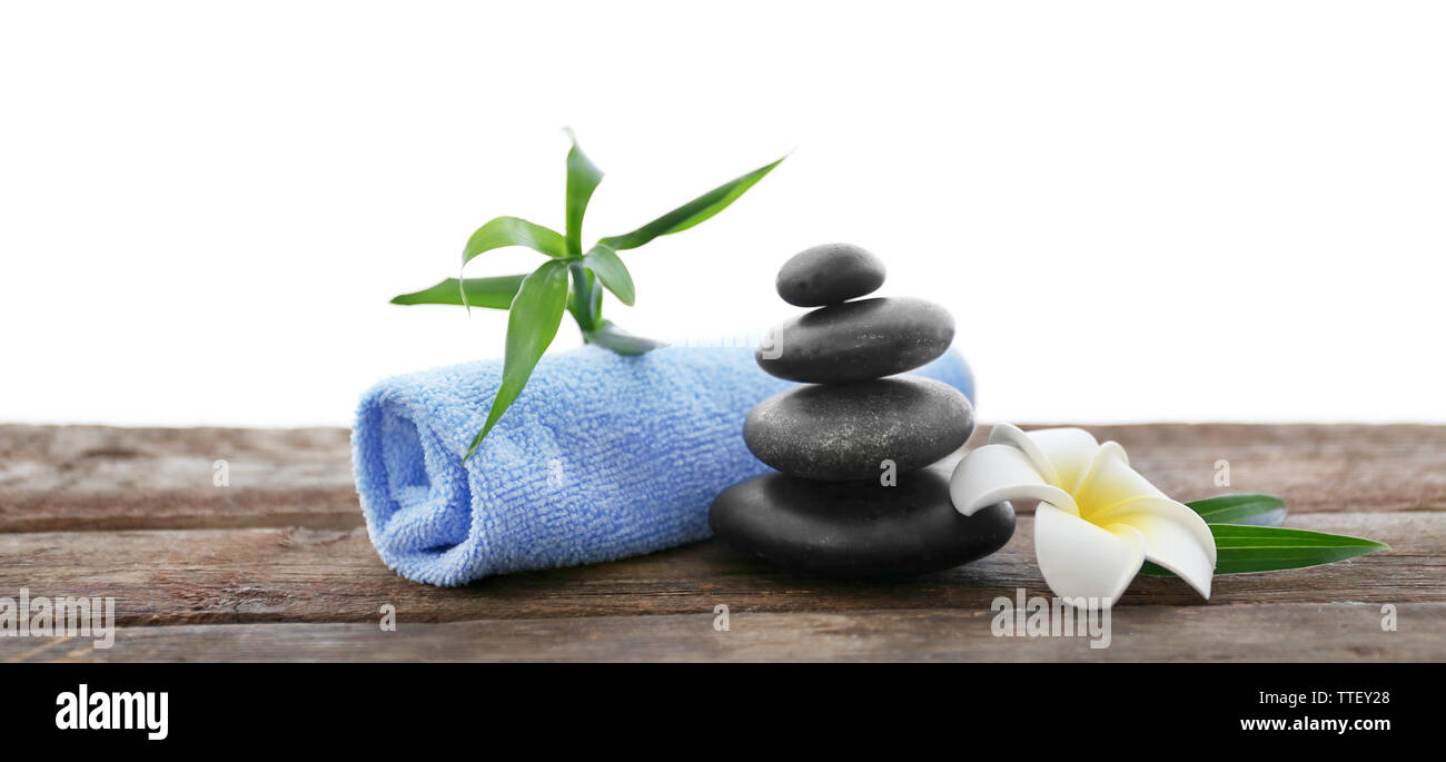 Wellness Steine mit Handtuch, Bambus und tropischen Blumen auf weiem  Hintergrund Stockfotografie - Alamy