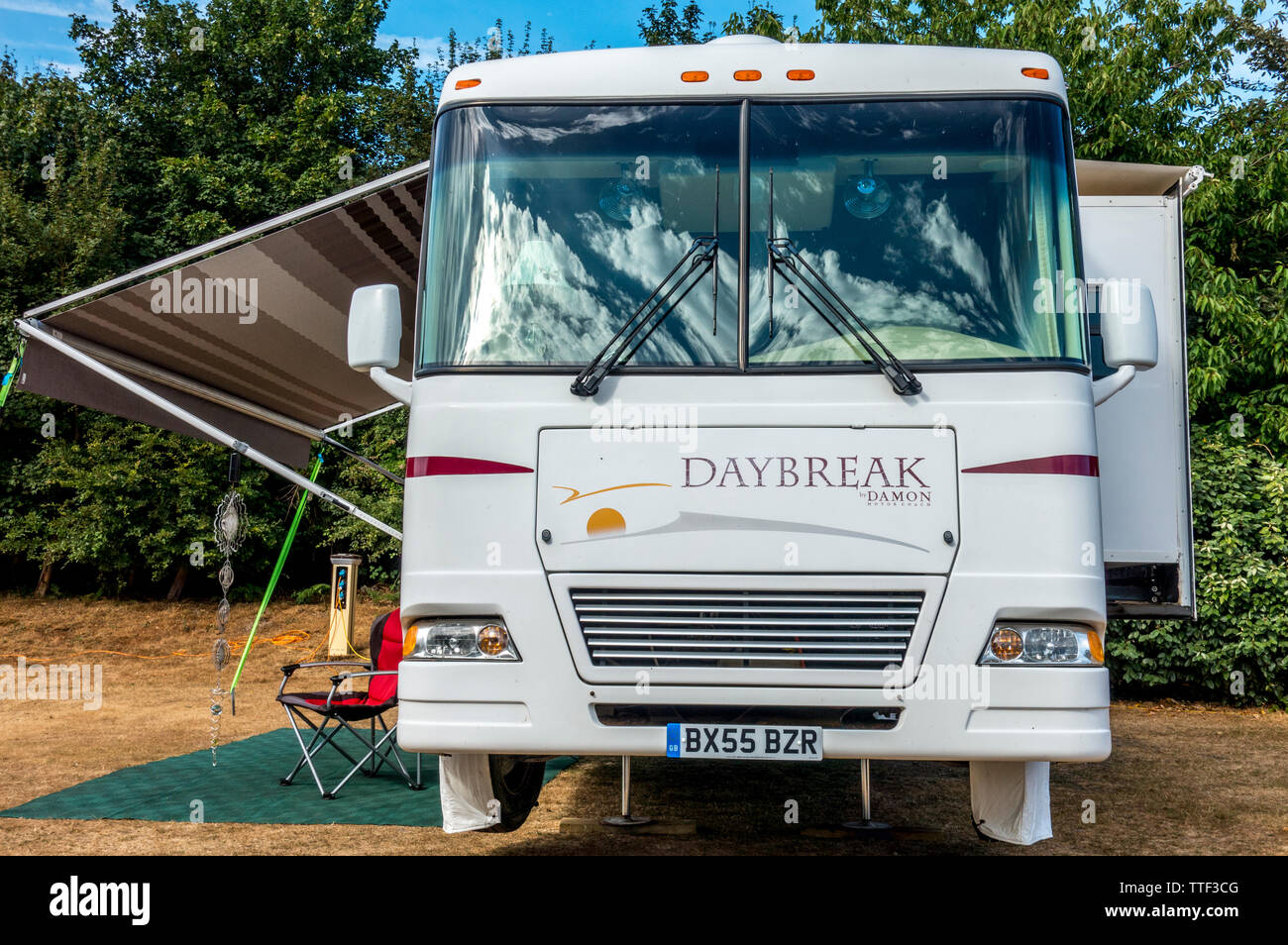 Vorderansicht eines weißen Damon Daybreak Reisemobil/RV, auf einem britischen Campingplatz geparkt, mit Folie, Zimmer und Markise in Gebrauch. Stockfoto