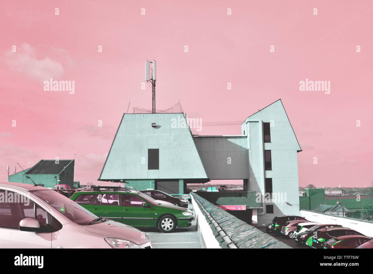 Parkplatz auf dem Dach in Bexleyheath, Mint Green brutalist Stil Gebäude, sowohl zeitgenössischer als auch Retro, pink Saccharin sirupartige Skies, feindlichen Farben Stockfoto