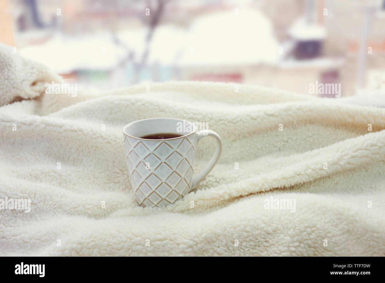 Tasse Tee und warme Decke auf der Fensterbank, Nahaufnahme Stockfoto