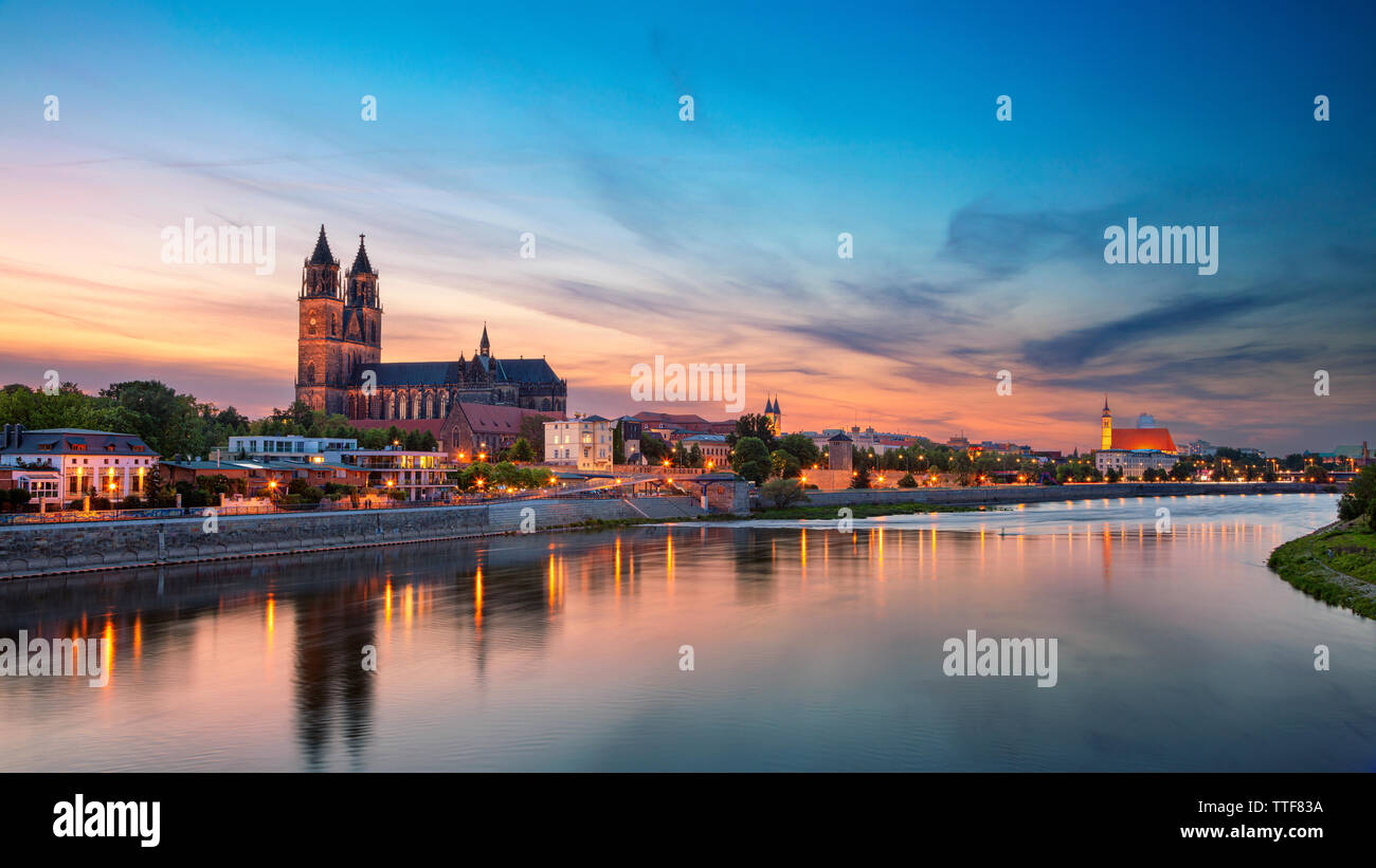 Magdeburg, Deutschland. Panoramablick auf das Stadtbild Bild von Magdeburg, Deutschland mit Reflexion der Stadt in der Elbe, während des Sonnenuntergangs. Stockfoto