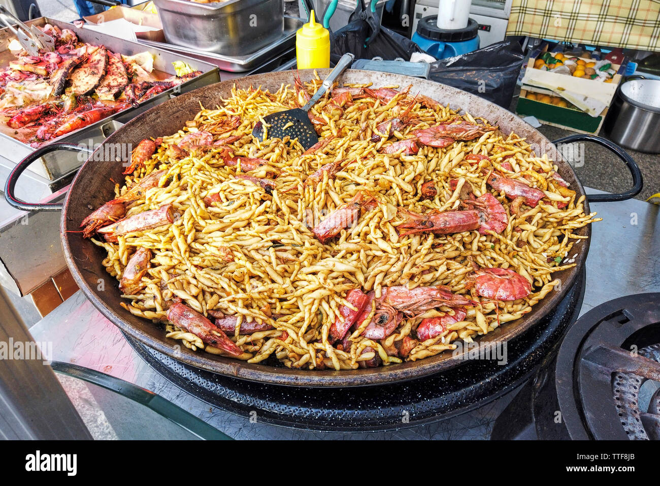 Italienische Street Food mit einem riesigen Topf Garnelen Pasta strozzapreti Stockfoto